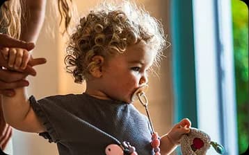 Enfant en bas âge tenant la main d'un adulte